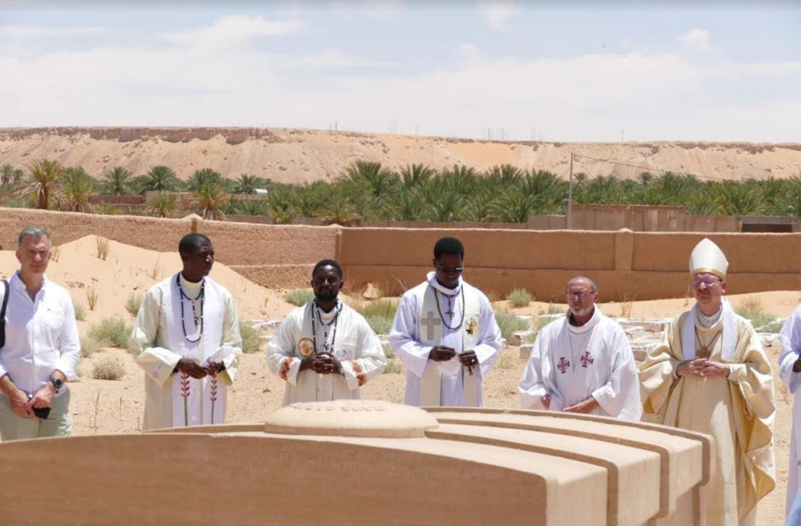 Jesús Cervera (junto al obispo) en la tumba de Carlos de Foucald