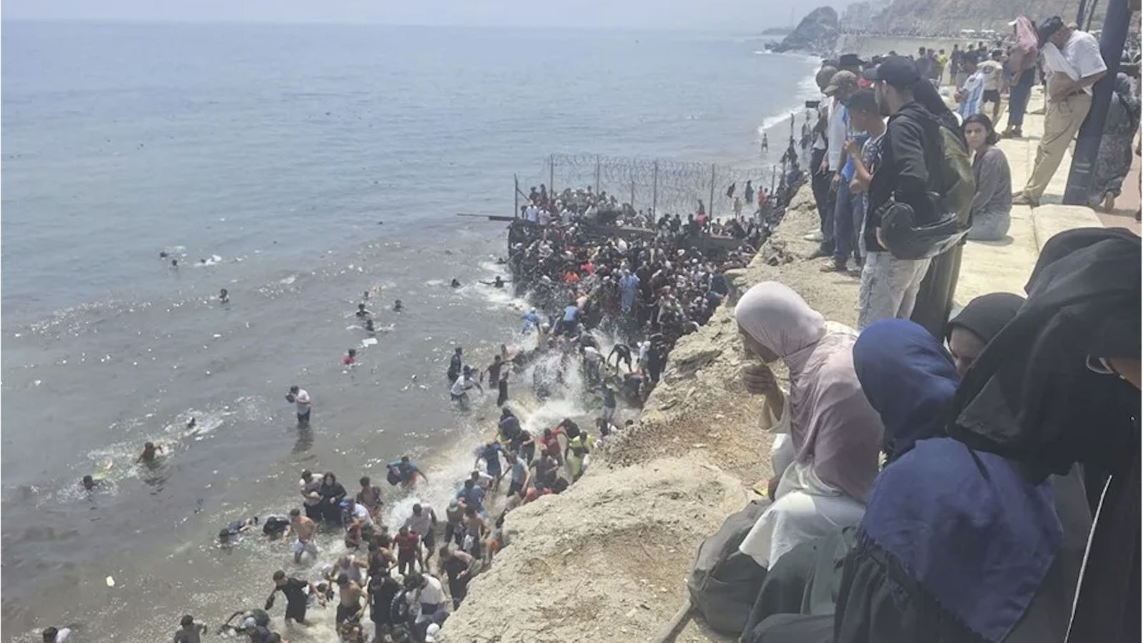 Jóvenes migrantes cruzando la frontera en Ceuta