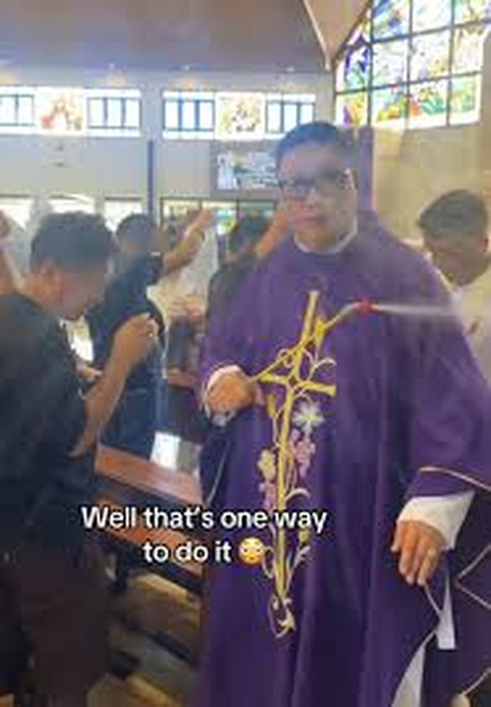 Sacerdote usando un rociador de agua para rociar los ramos en Filipinas