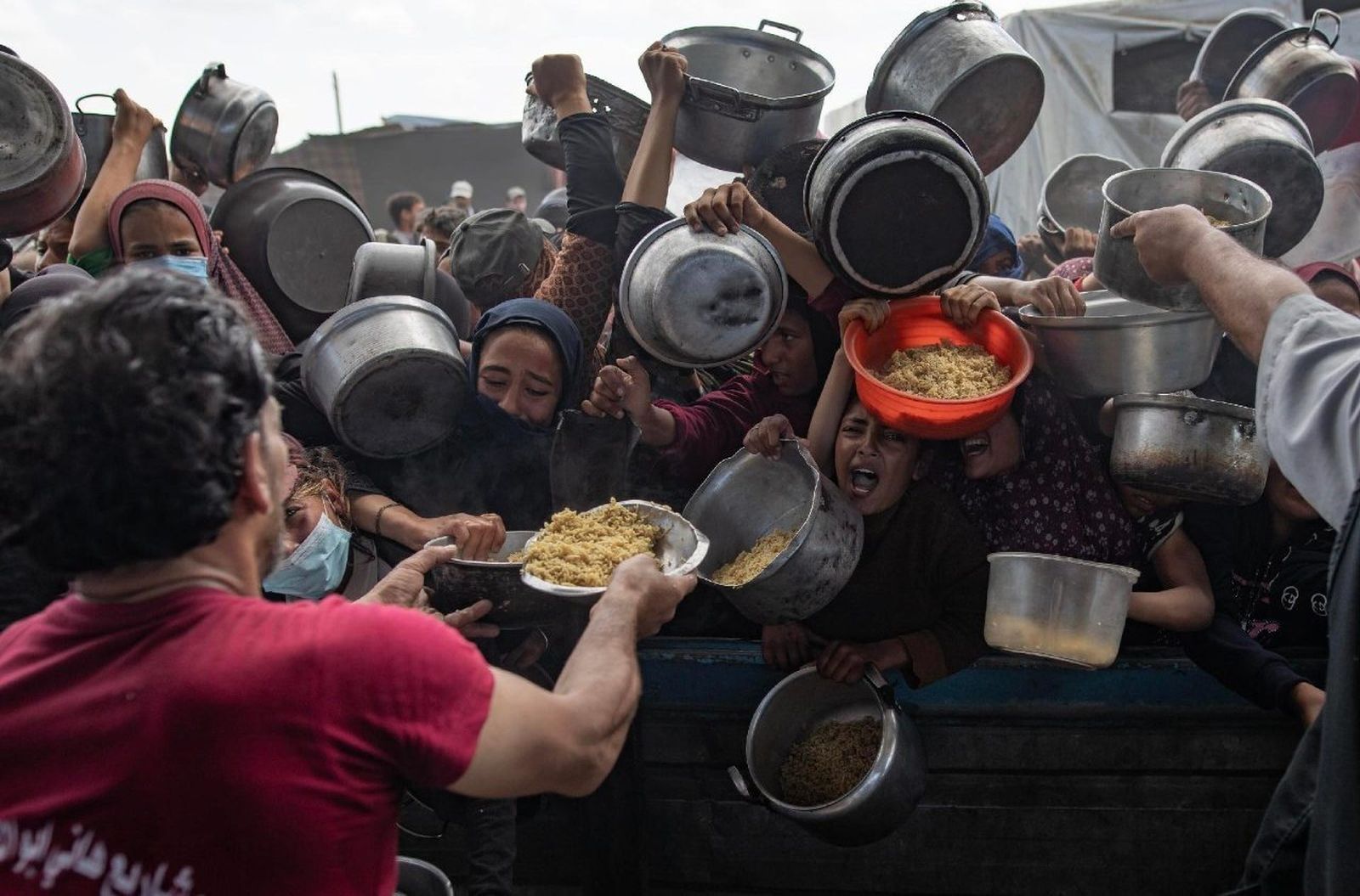 Palestinos desplazados se reúnen para recibir alimentos en Khan Younis, en el sur de Gaz