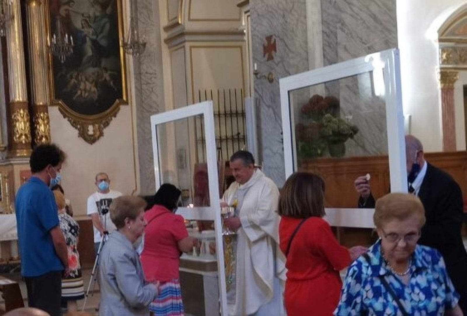 Dar la comunión tras mamparas de cristal