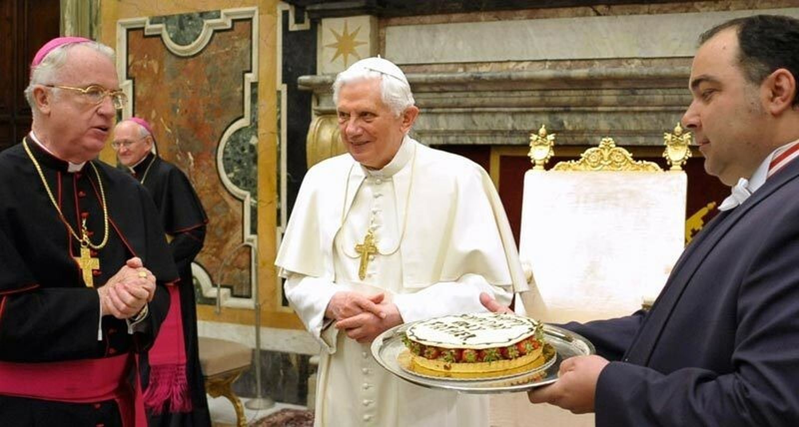 Michael J. Bransfield (i) presenta una tarta de cumpleaños al Papa Benedicto XVI