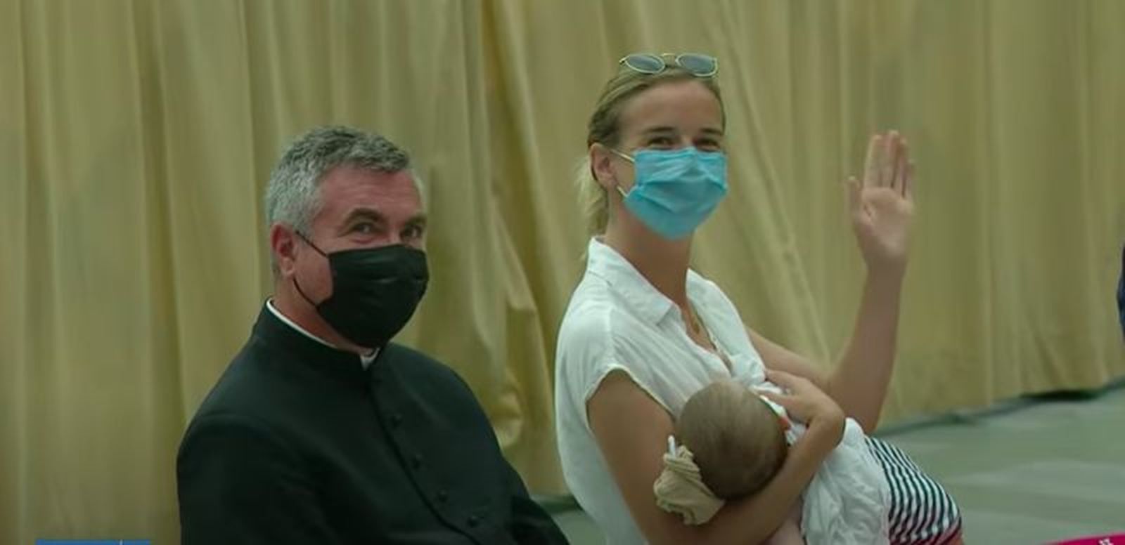 Un sacerdote, una madre y su hijo saludan al Papa