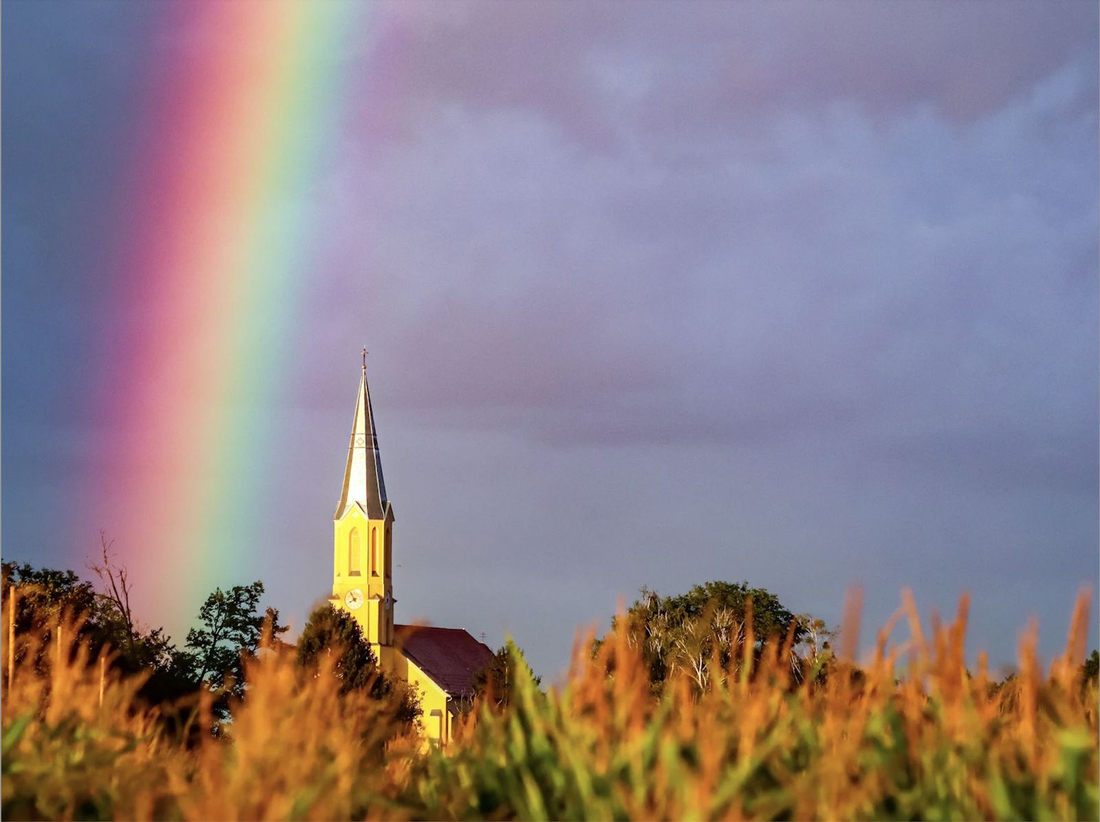 Una iglesia con un arcoíris