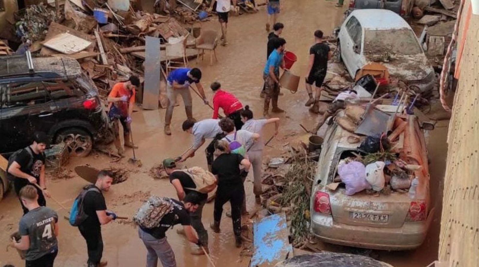 Gente despejando calles arrasadas por la dana