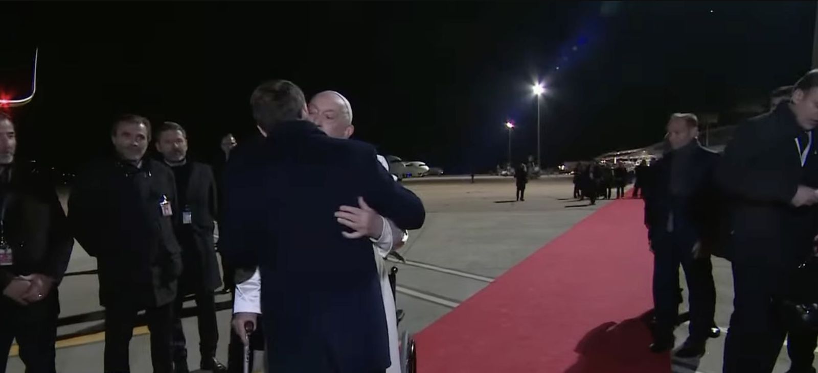 El beso de Francisco y Macron junto a la escalinata del avión