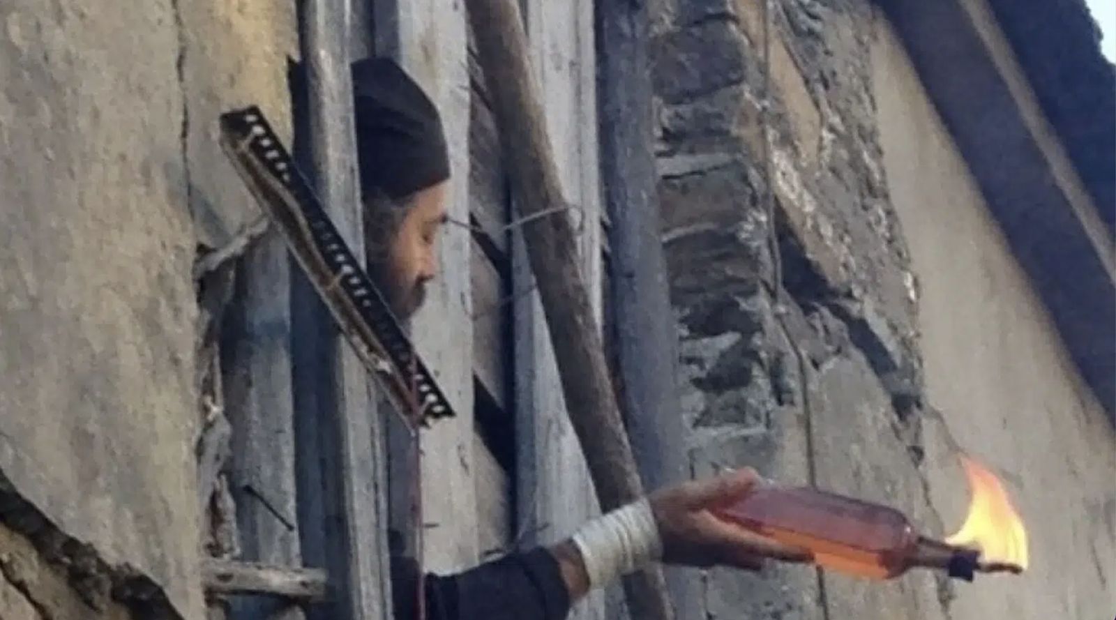 Un monje lanza un cóctel molotov a la policía en 2013