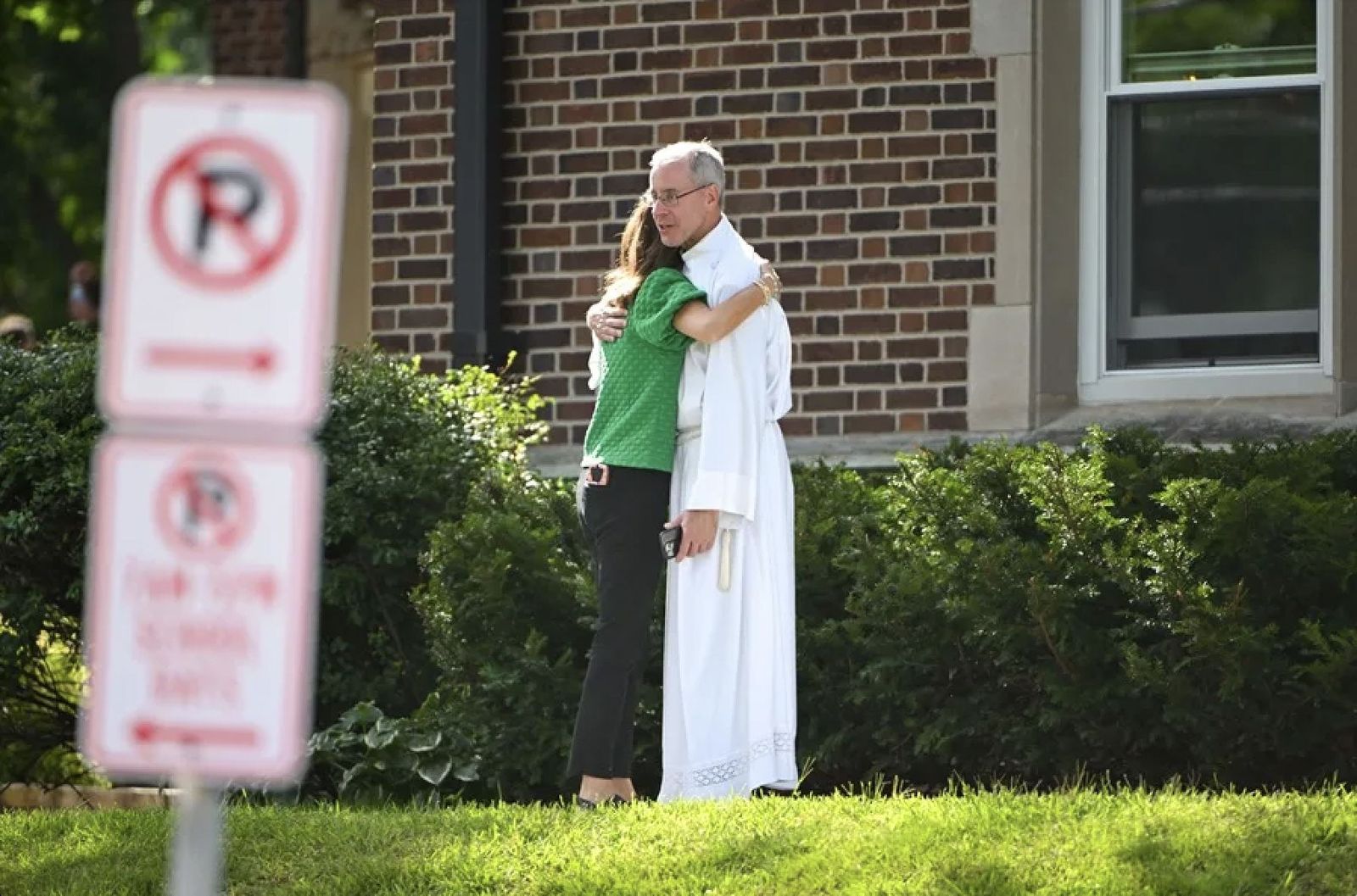 Un sacerdote consuela a una mujer tras el tiroteo en la escuela