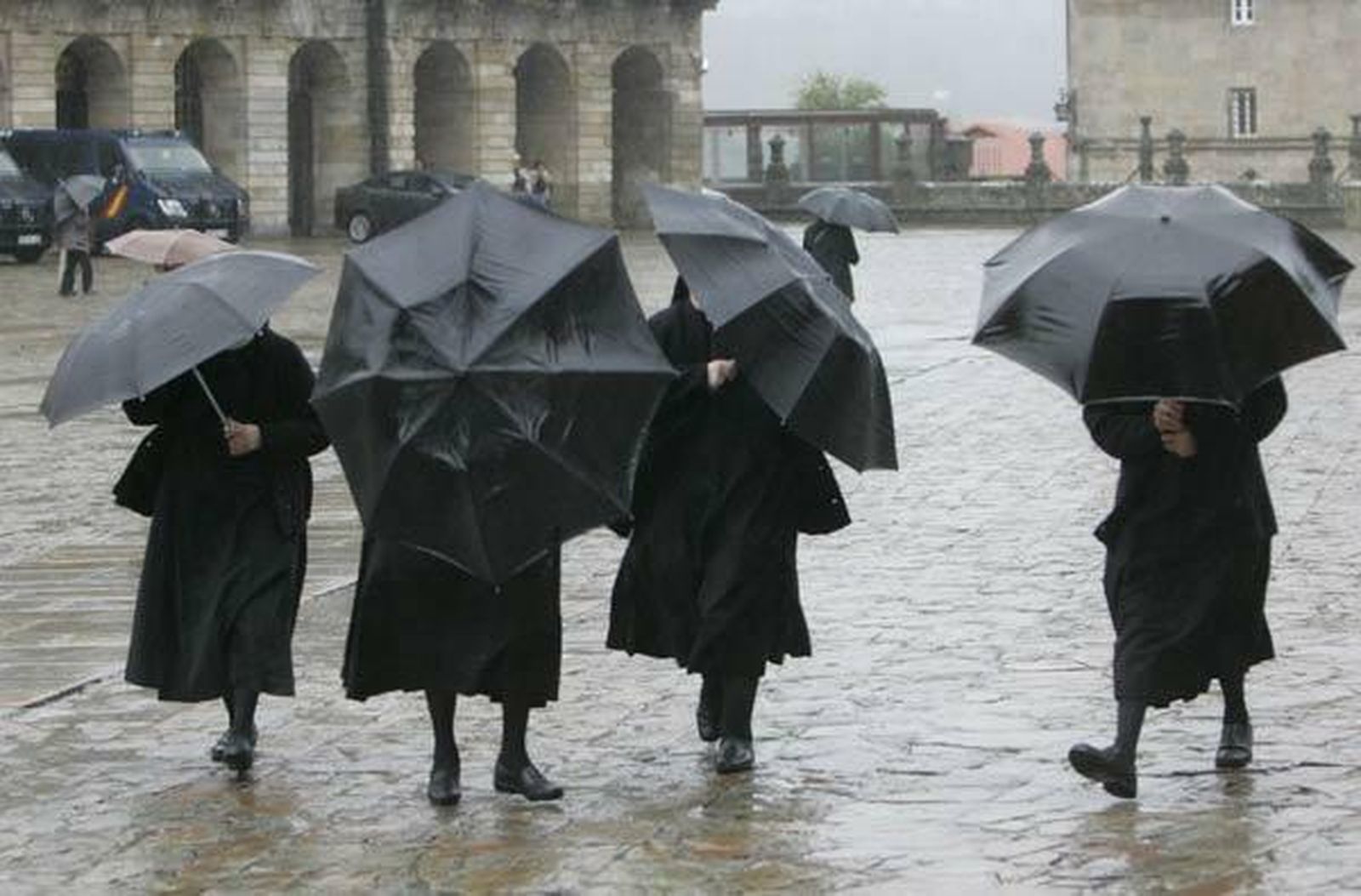 Un grupo de monjas se protege de la lluvia