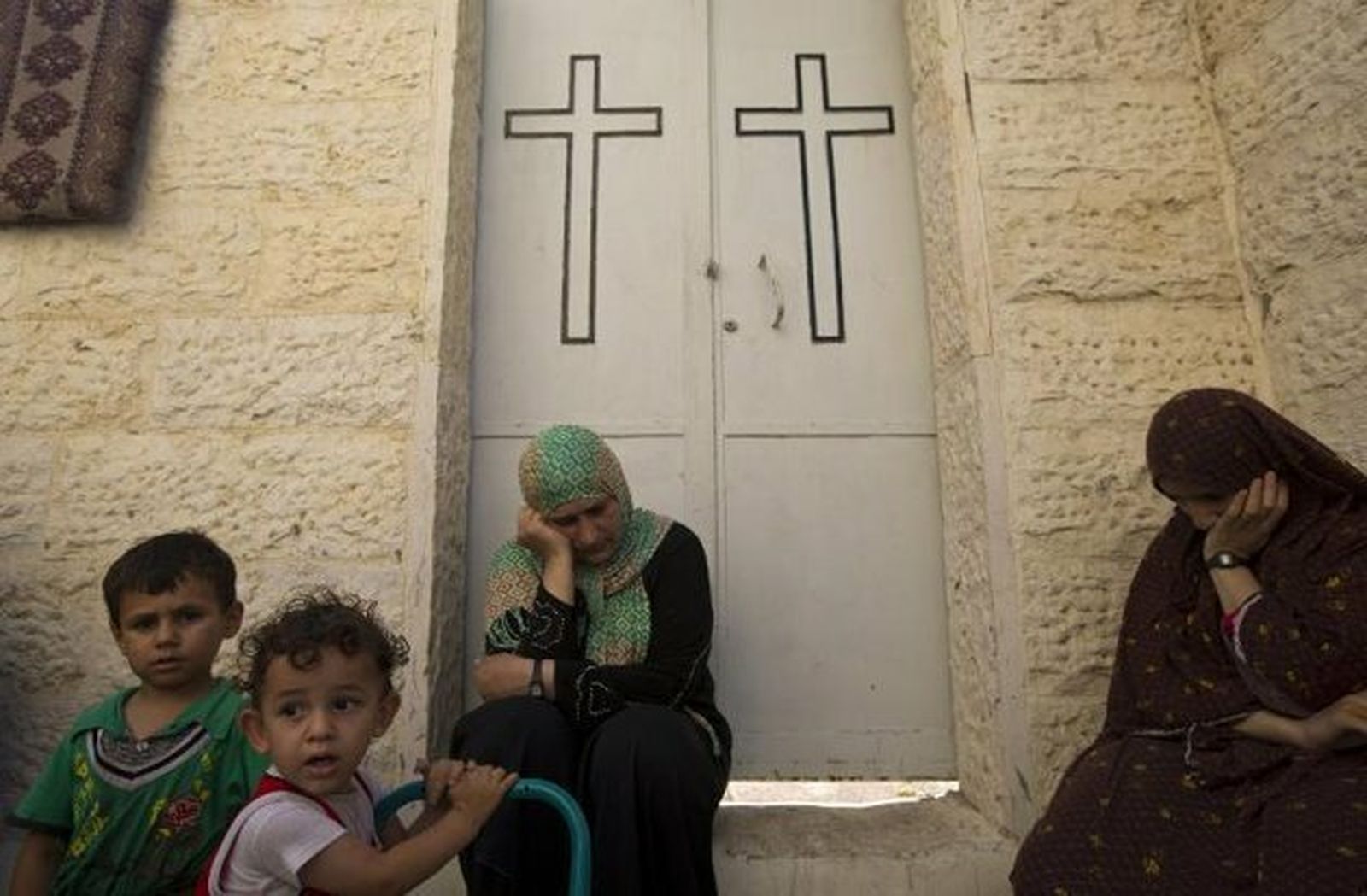 Mujeres y niños en la puerta de una iglesia de Gaza
