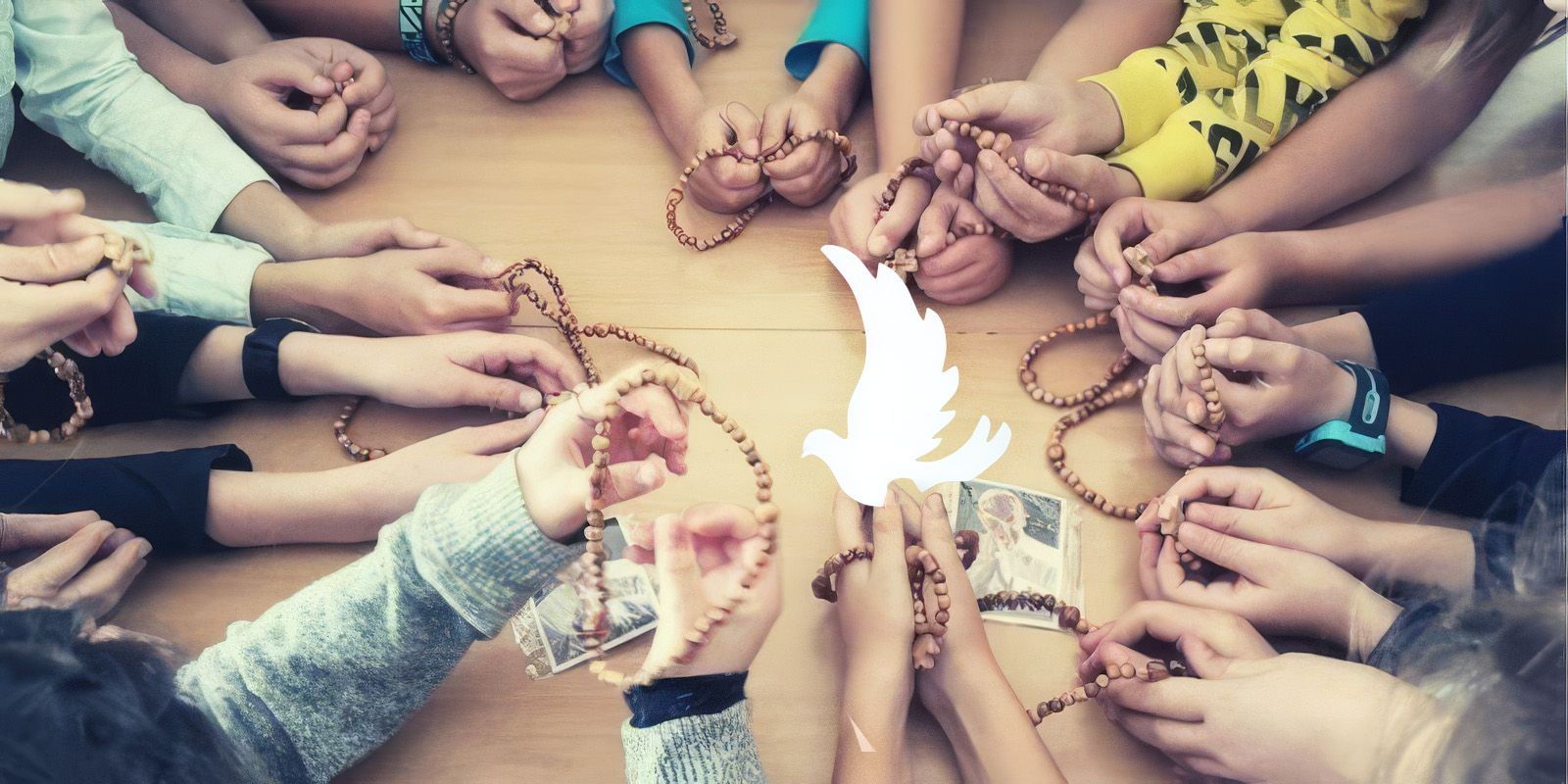 Manos infantiles rezando el rosario por la paz