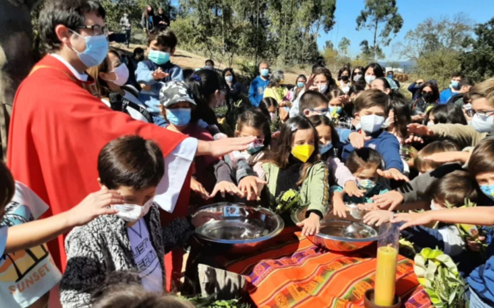 Nicolás Viel bendice el agua jen una liturgia con niñas y niños de una población de Santiago