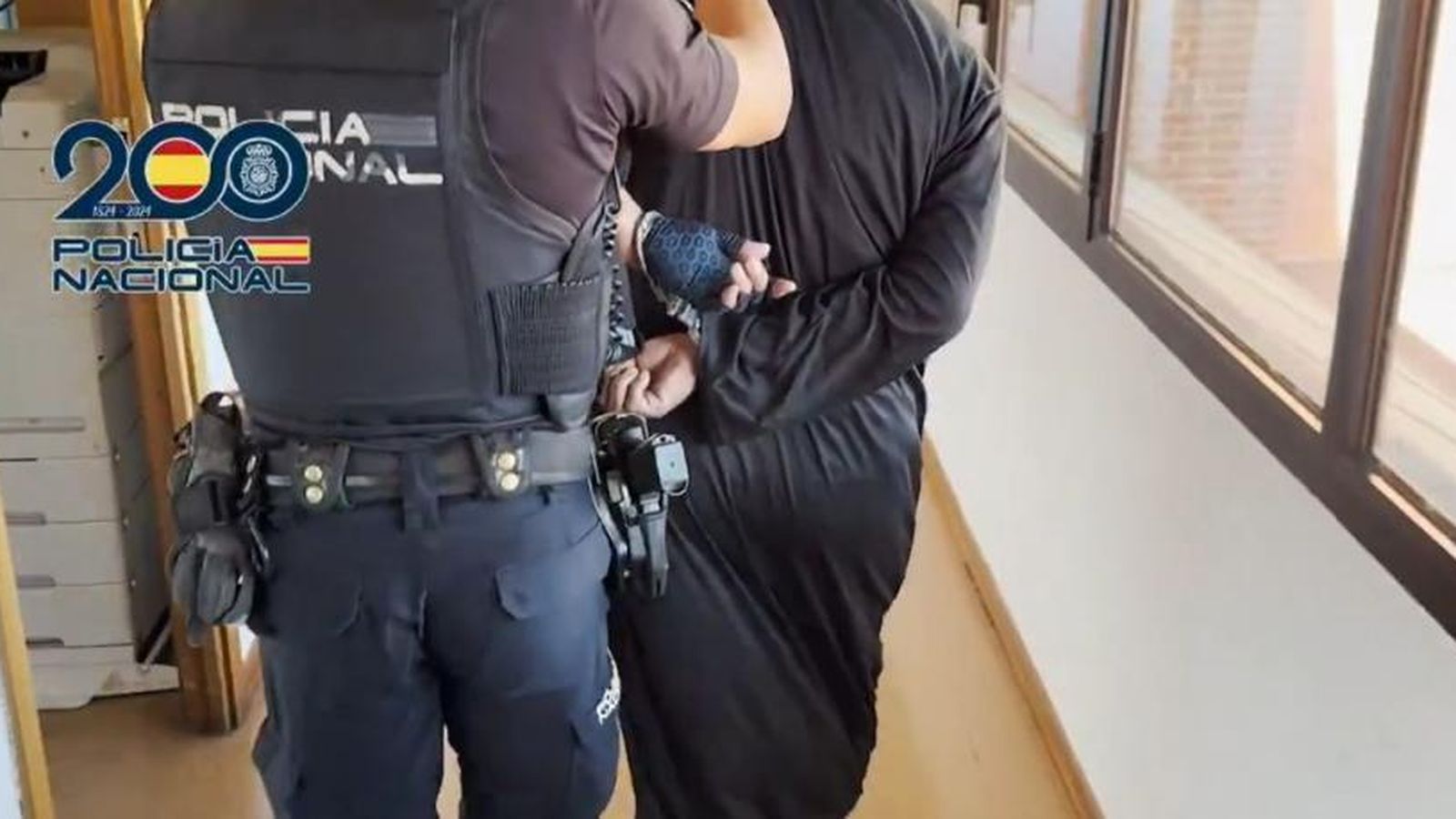 Un agente escoltando a un detenido
