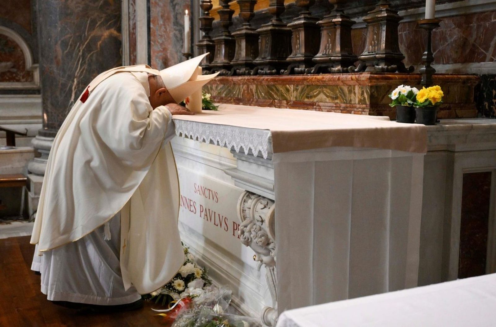 Dziwisz reza ante la tumba de san Juan Pablo II