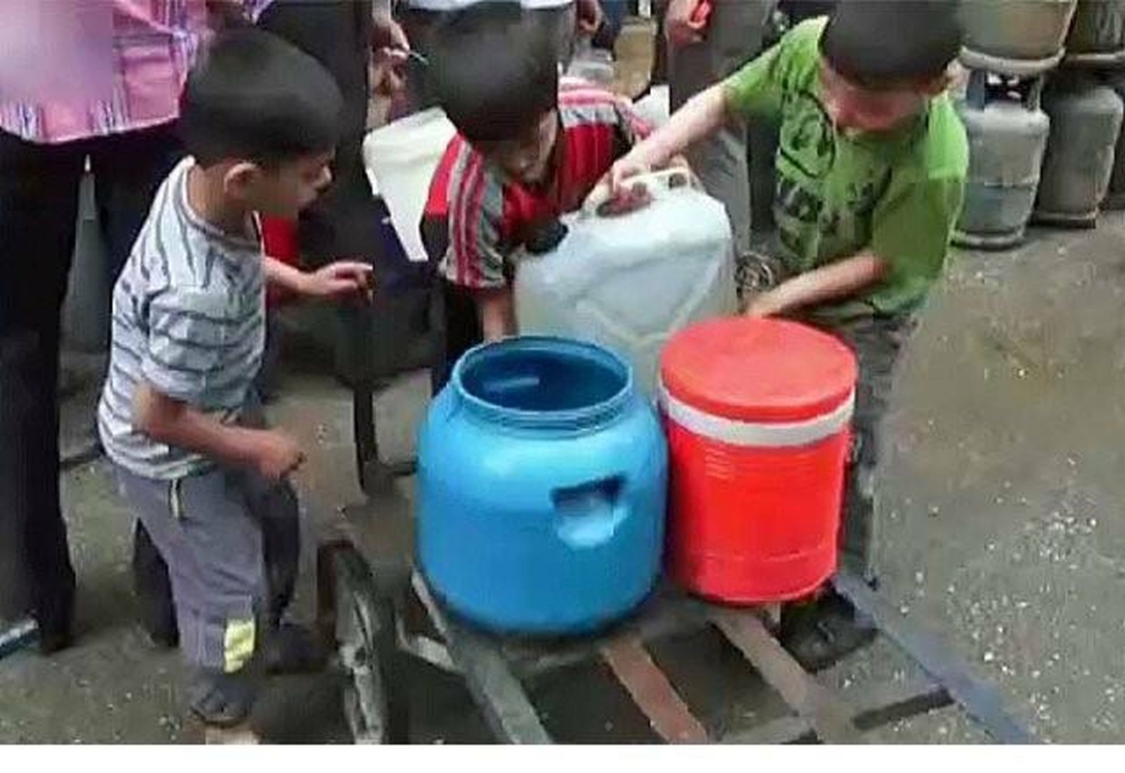 Niños recogen agua en Alepo