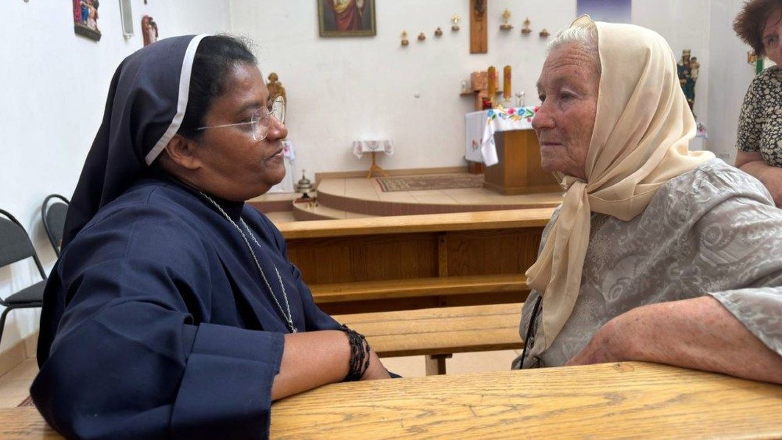 La hermana Liji Paiapilli escucha a una anciana ucraniana en Jersón