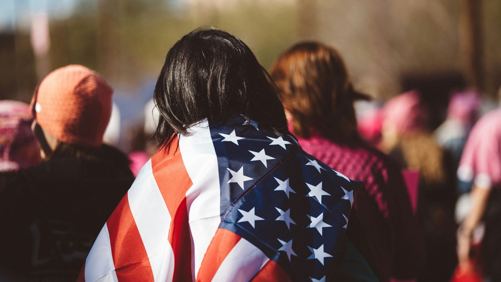 Una mujer, envuelta en la bandera de los estados Unidos
