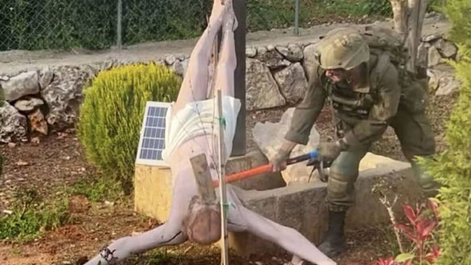 Un soldado israeli destroza la imagen de un cristo en el sur del Líbano
