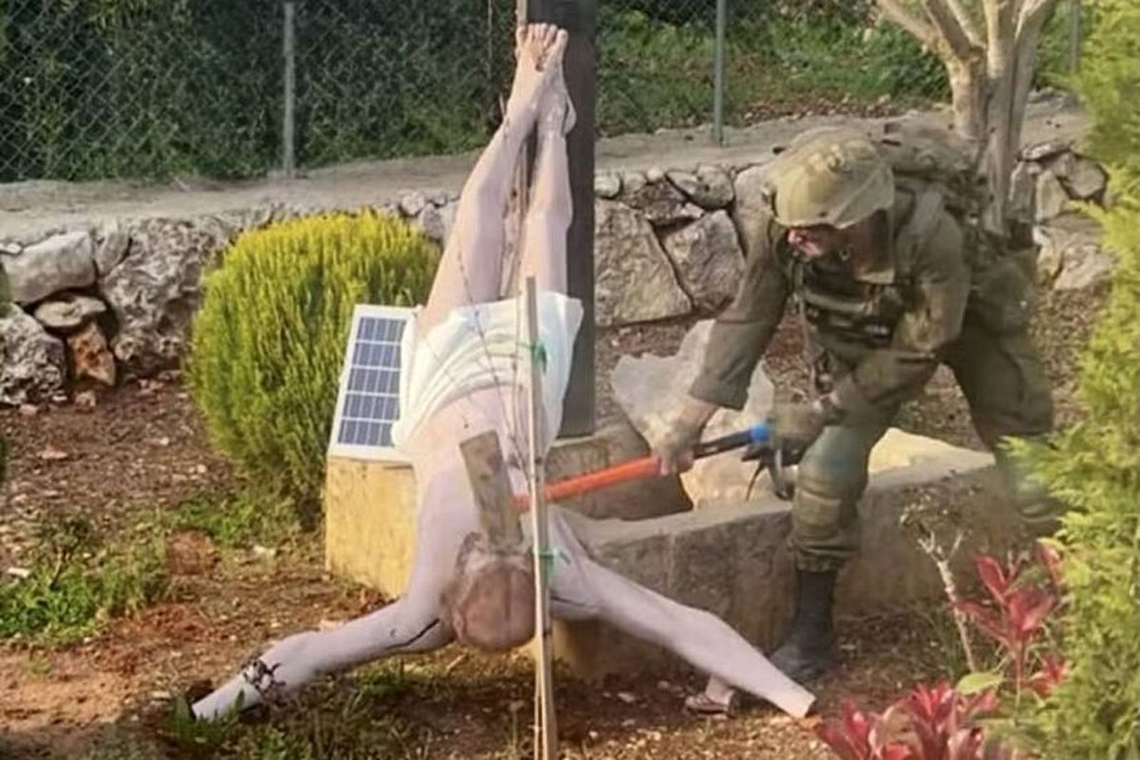 Un soldado israeli destroza la imagen de un cristo en el sur del Líbano