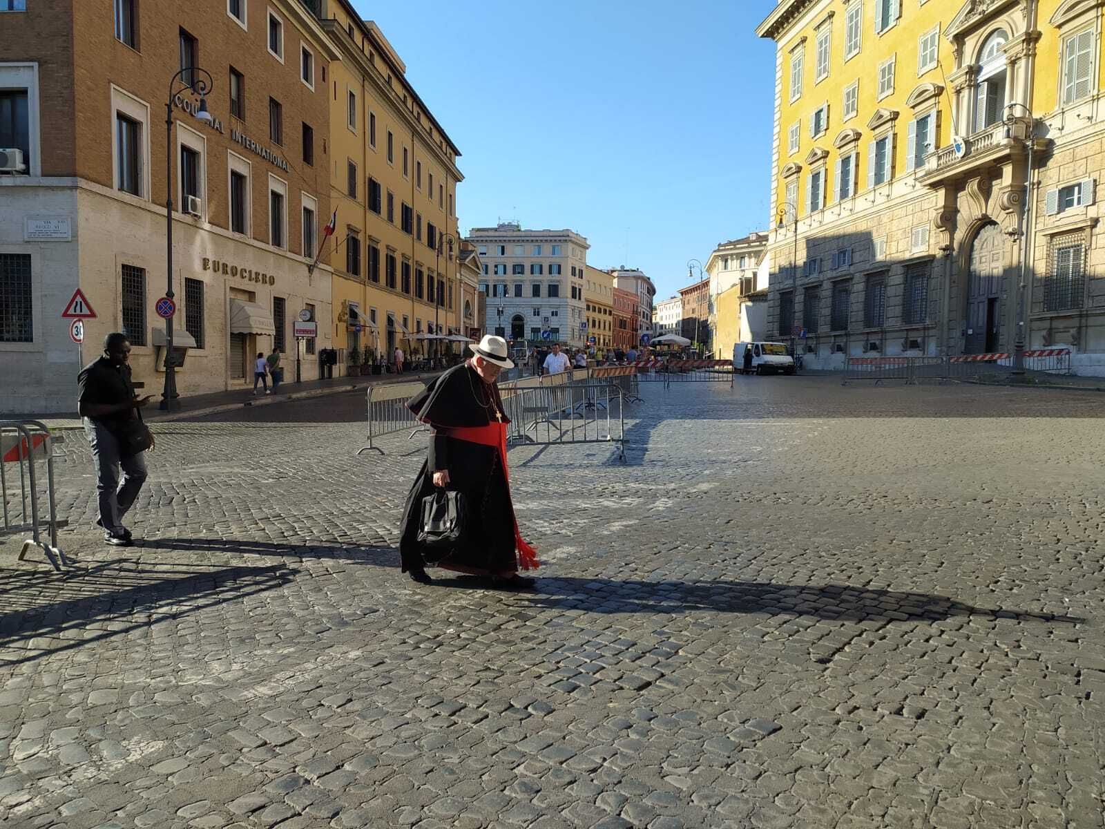 El cardenal Burke, con gorro de paja, entrando en el Vaticano