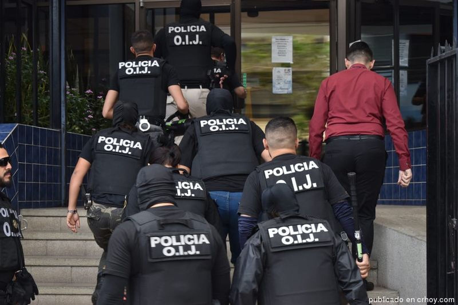 Policías entrando a un edificio de la Iglesia en Costa Rica