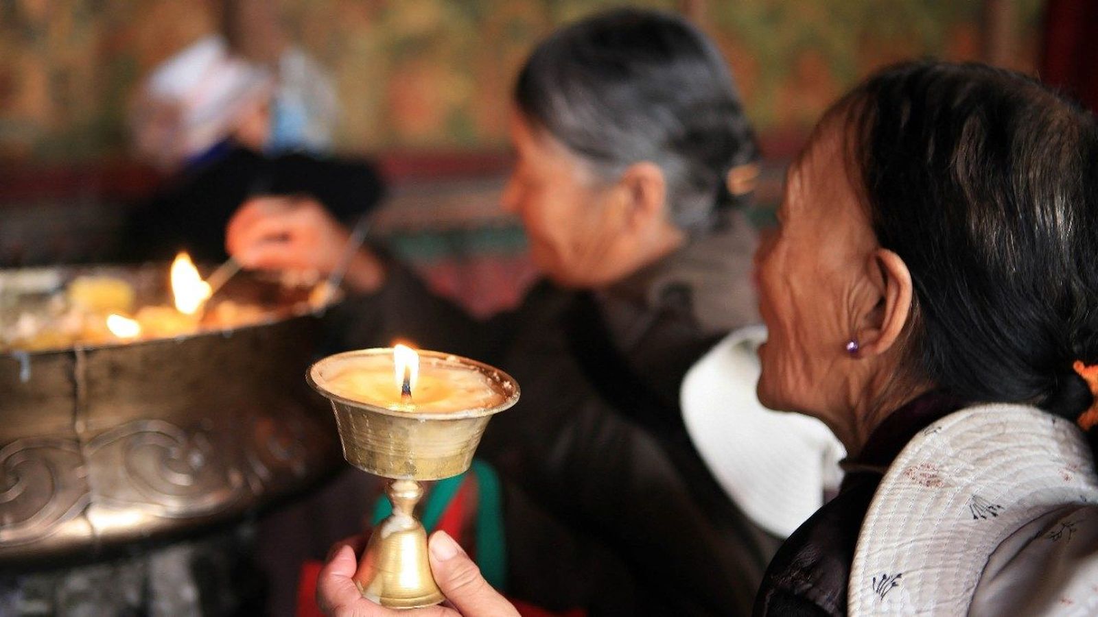 Gente en China encendiendo velas para rezar