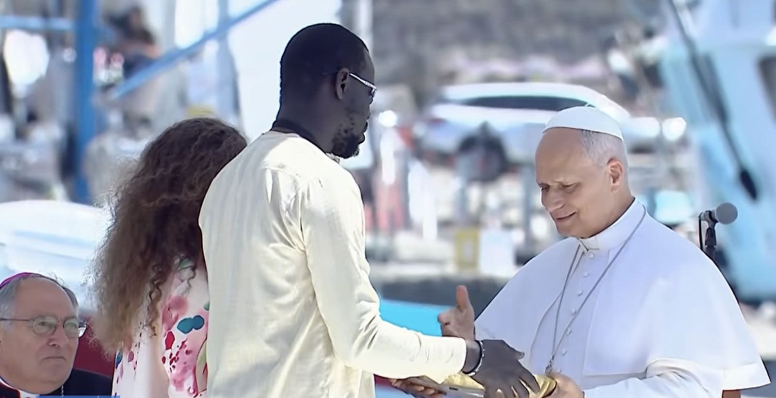 El Papa saluda a dos migrantes