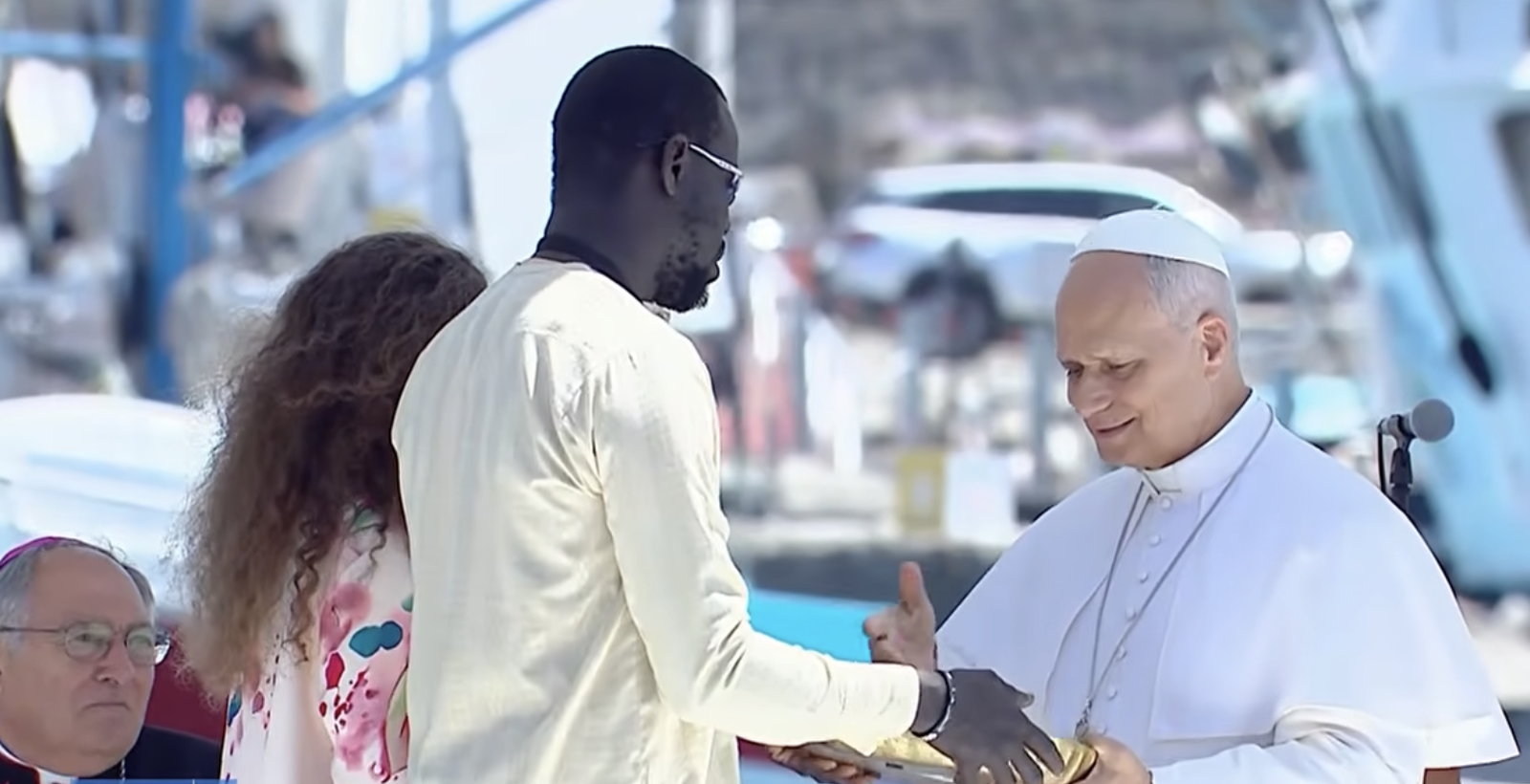El Papa saluda a dos migrantes
