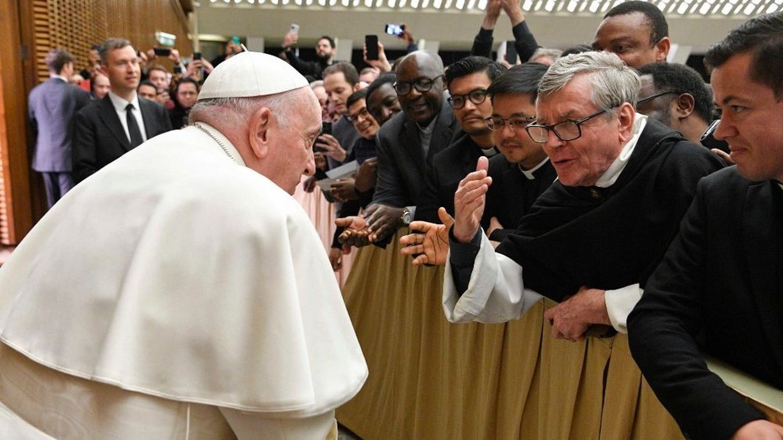 Francisco conversa con un religioso durante la Audiencia