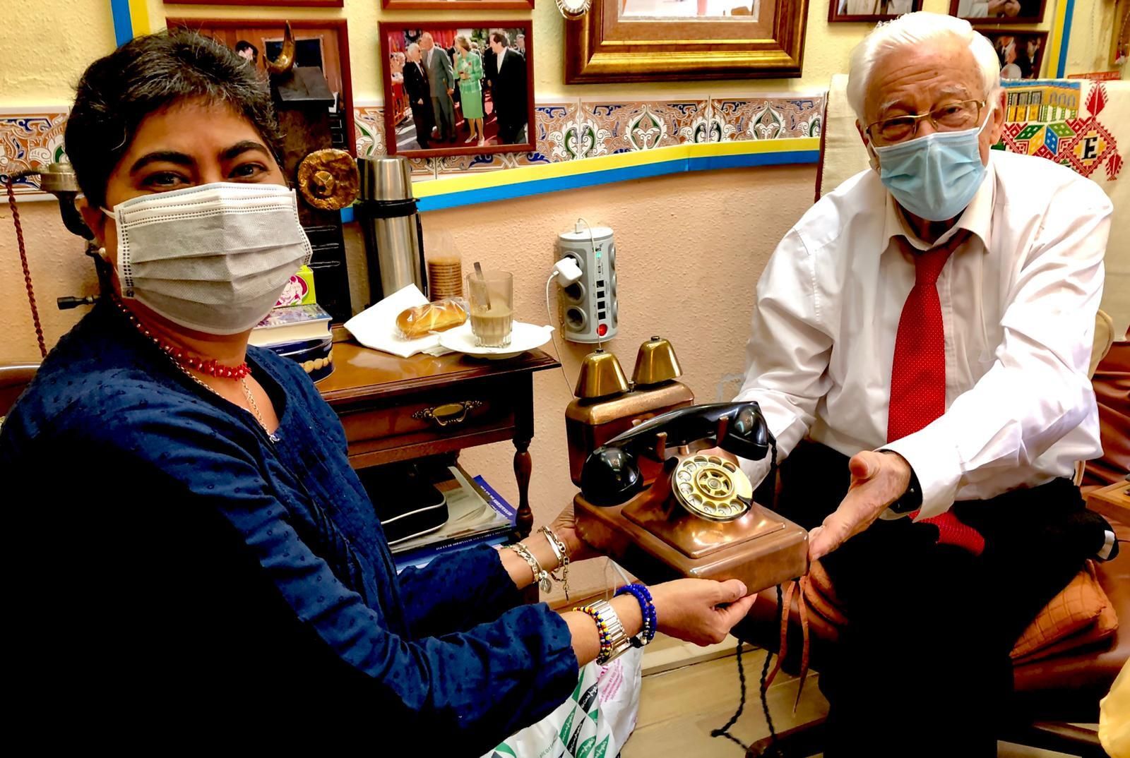 Ana María Brea con el padre Ángel sosteniendo uno de los teléfonos