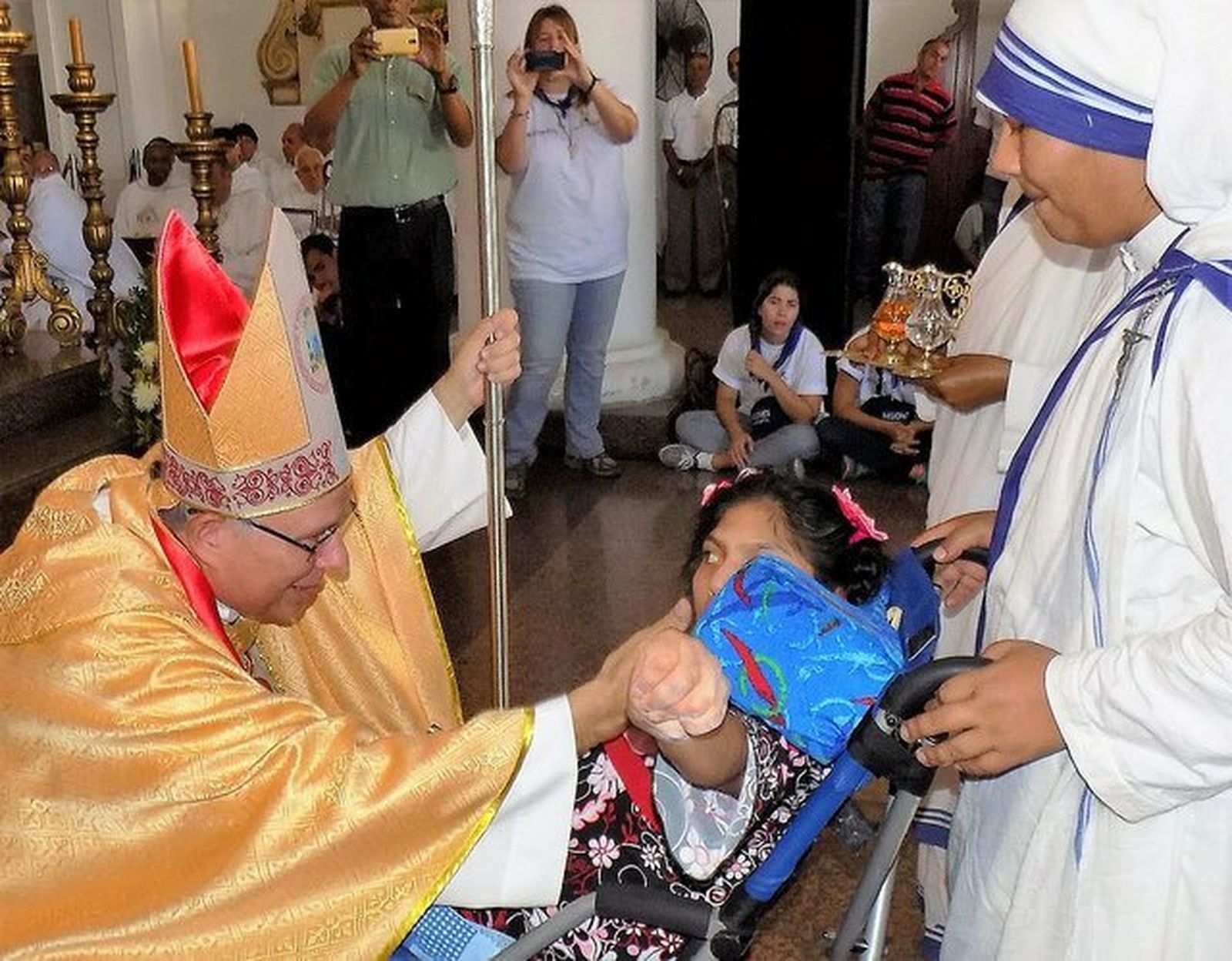 Monseñor Raúl Biord acaricia a una niña