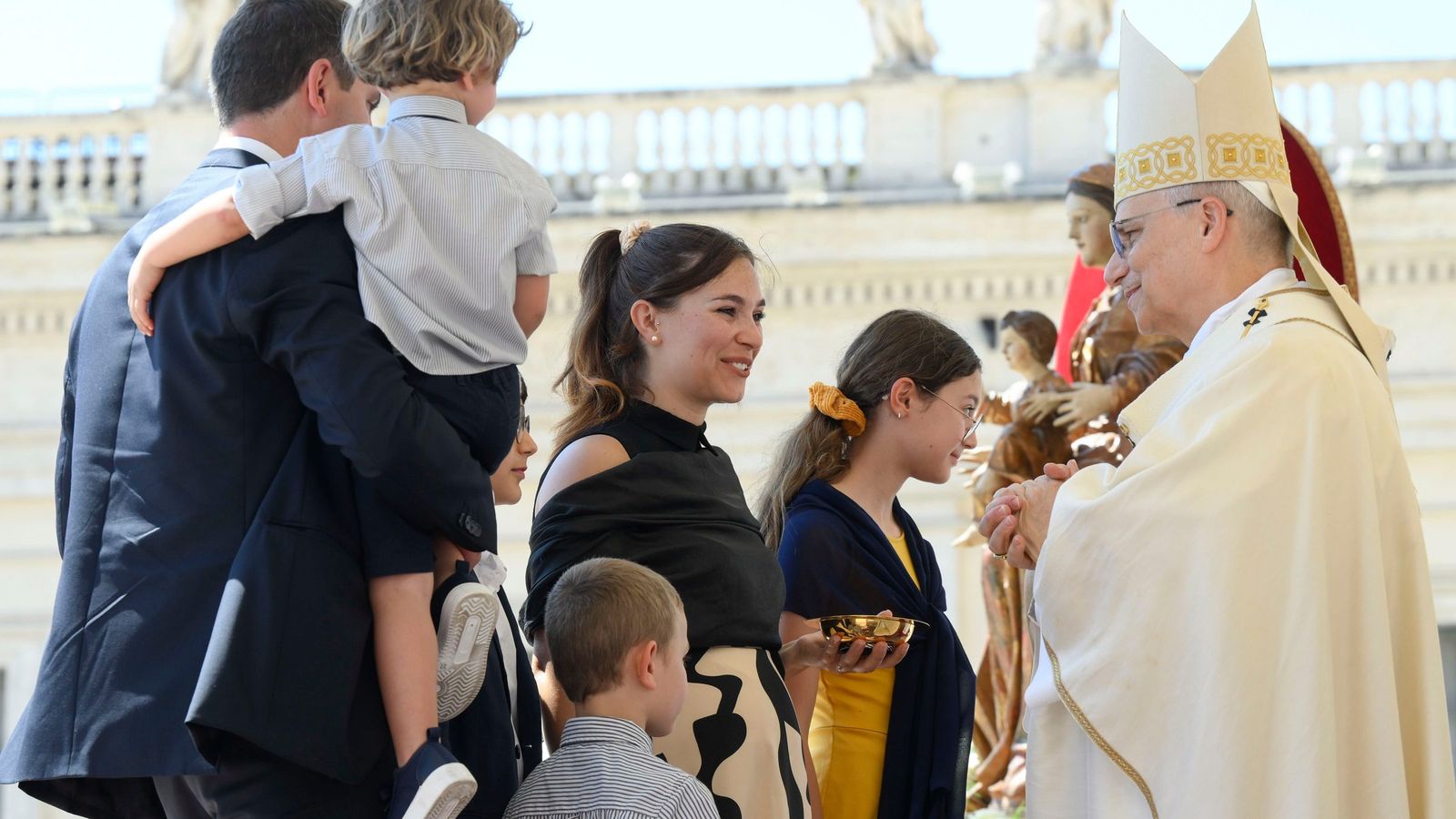 El papa León XIV junto a una familia durante una misa en la Plaza de San Pedro