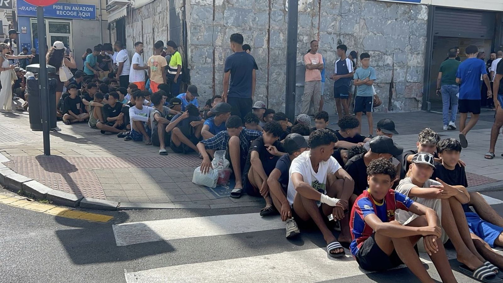 Menores marroquies esperan a ser registrados en una comisaría de Ceuta