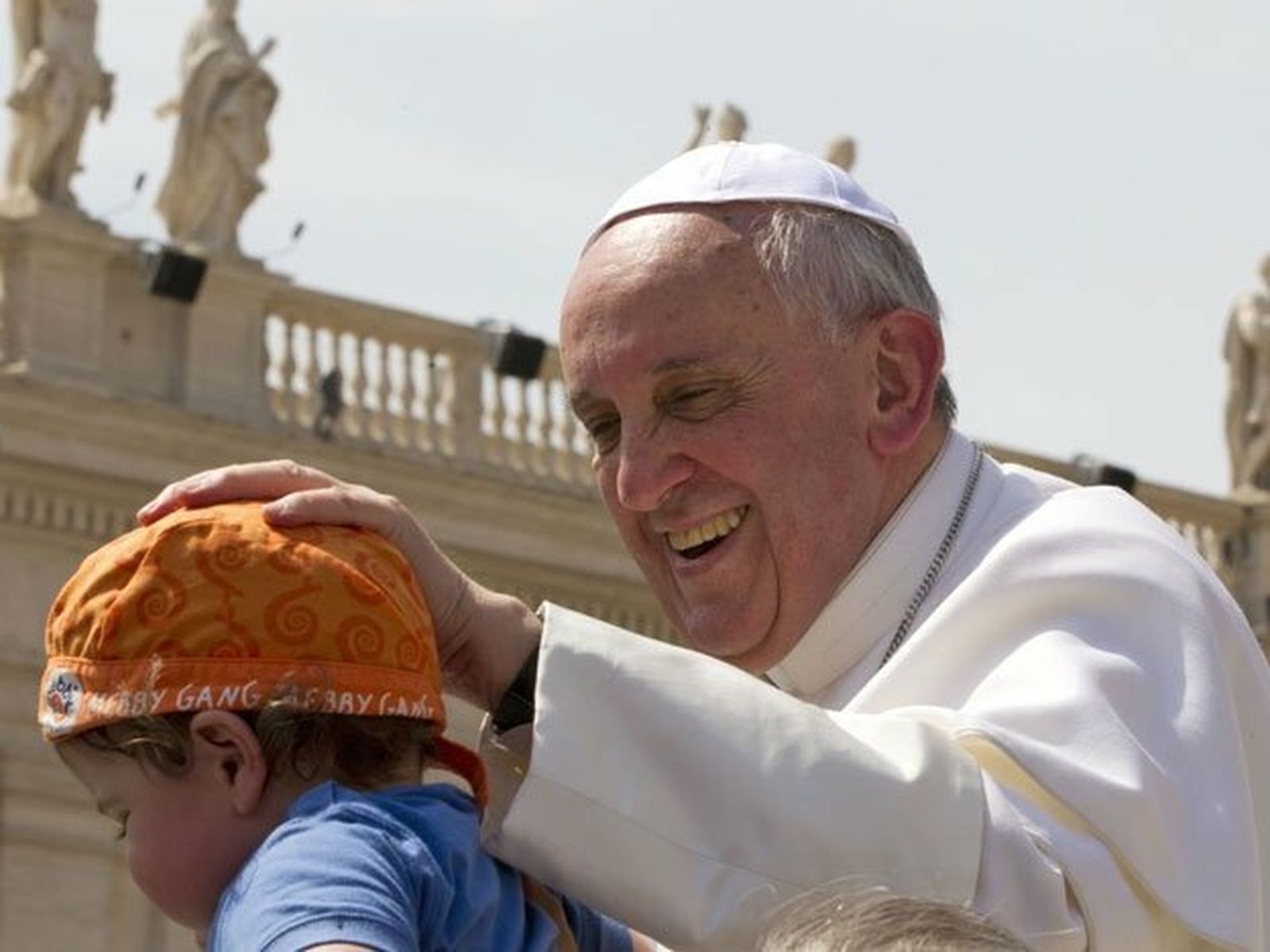 Francisco acaricia a un niño